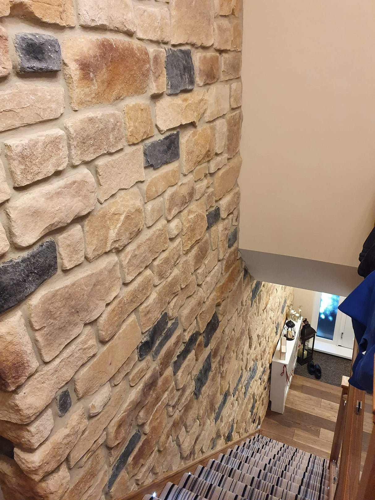 Stone Cladding Antique Blend on a staircase wall, showcasing a natural aesthetic with varied textures and colors.