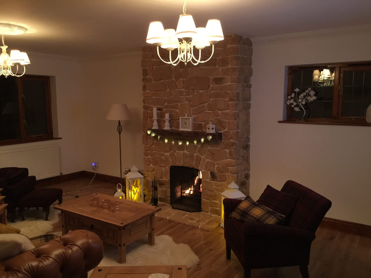 Cozy living room featuring a stone cladding fireplace with warm lighting and comfortable seating.