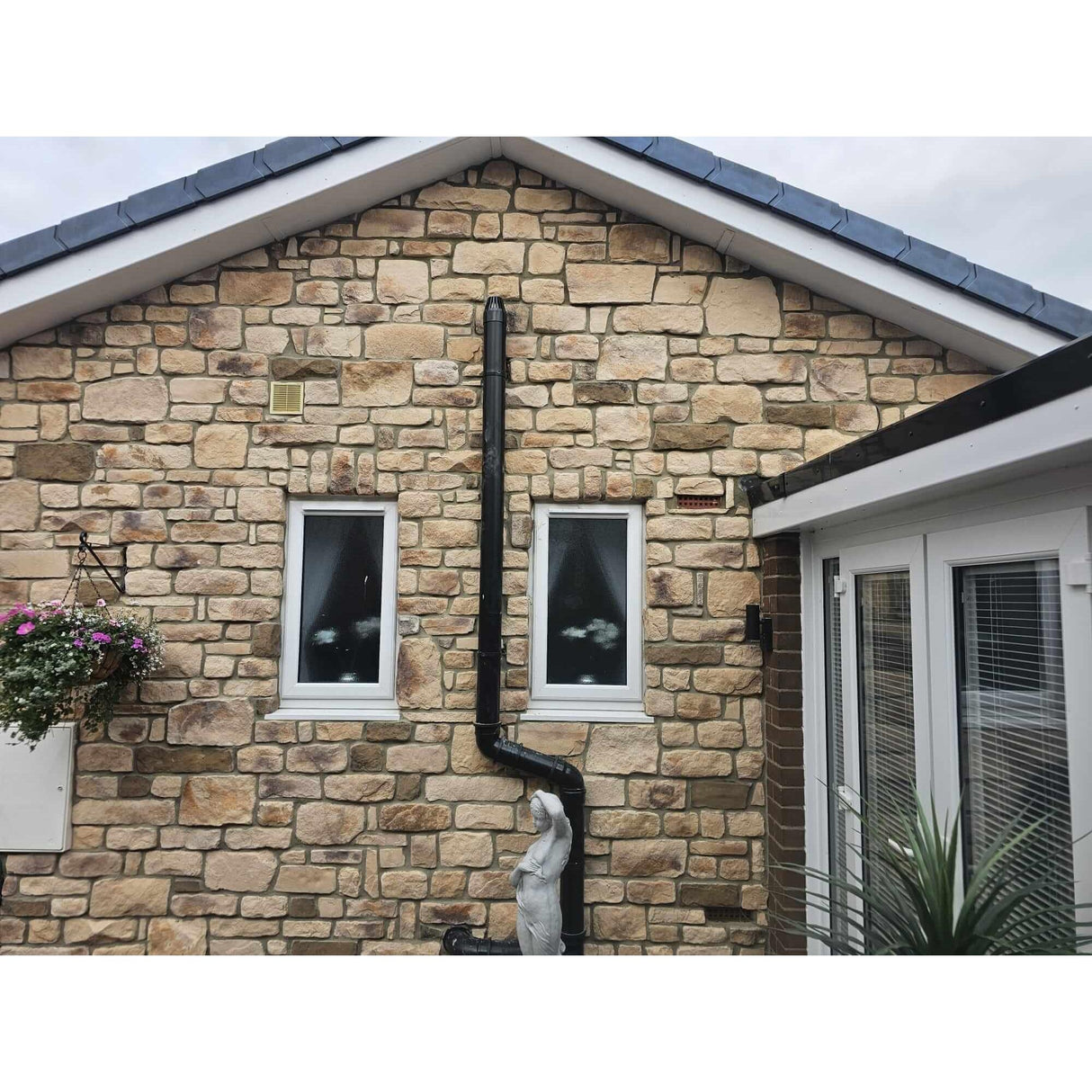 Stone cladding featuring a sandstone blend on a residential home exterior with window details.