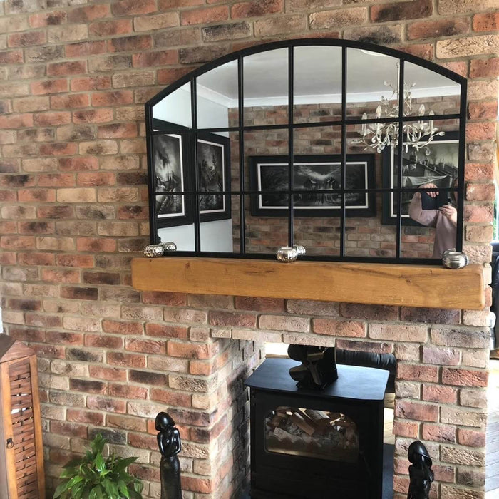 Stylish interior featuring a mirror above a brick fireplace, enhancing rustic decor with a Mayfair Blend Brick slip wall.