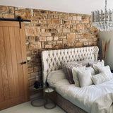 Cozy bedroom featuring stunning Burnt Buff Blend stone cladding wall and elegant tufted bed with decorative pillows.
