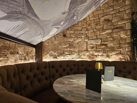 Cozy dining area with burnt buff blend stone cladding walls and elegant marble table, creating a warm ambiance.