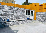 Modern outdoor space featuring light grey stone cladding walls and a wooden fence, showcasing a stylish design.