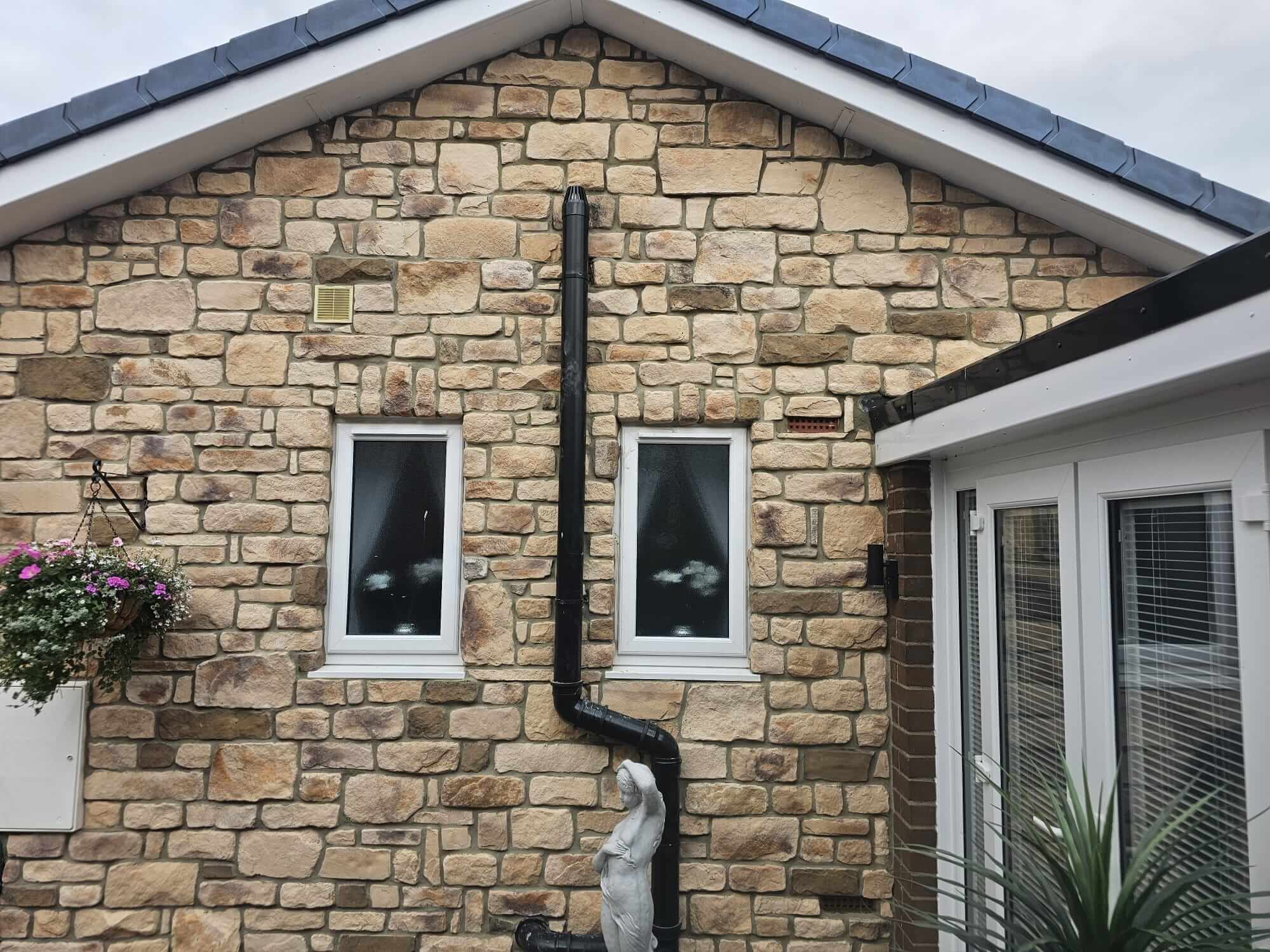 Stone cladding featuring a sandstone blend on a residential home exterior with window details.