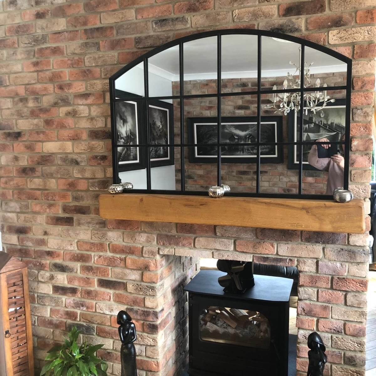 Stylish interior featuring a mirror above a brick fireplace, enhancing rustic decor with a Mayfair Blend Brick slip wall.