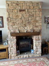 Stone-clad fireplace featuring Burnt Buff Blend stone slips, stylishly designed for a warm living area.