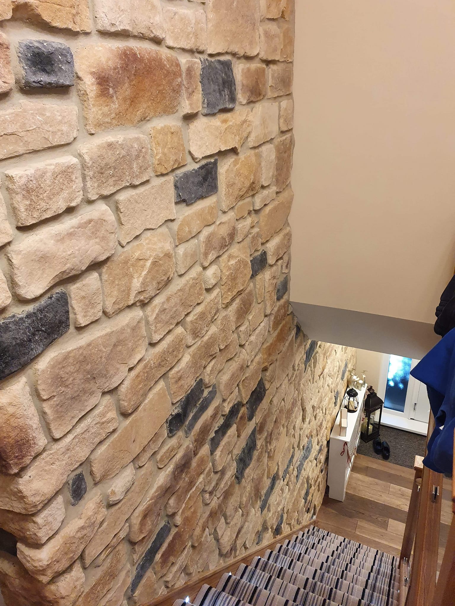 Stone Cladding Antique Blend on a staircase wall, showcasing a natural aesthetic with varied textures and colors.