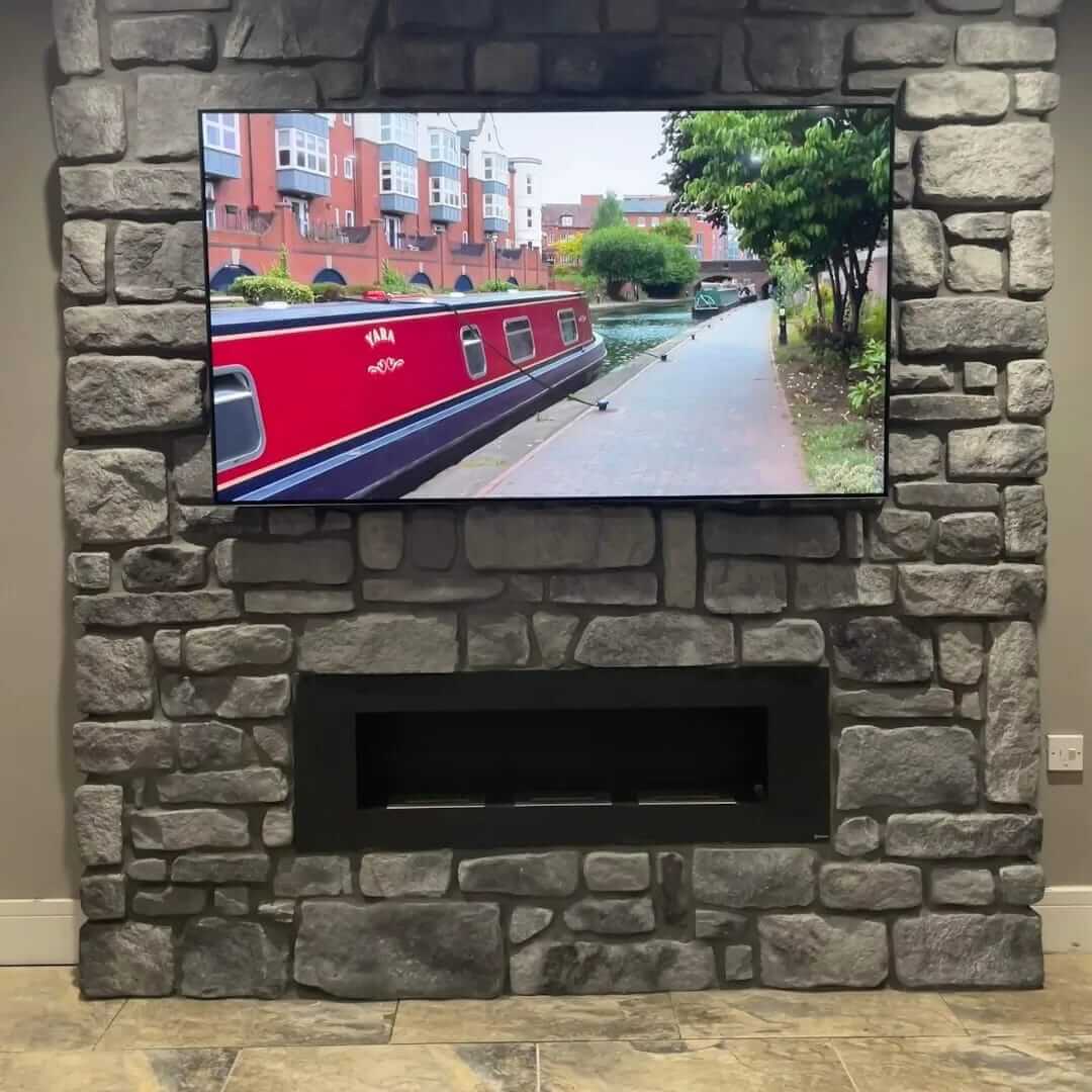 Stone cladding fireplace with a mounted TV, showcasing a canal view, enhancing home decor with natural aesthetics.