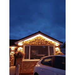 Stone cladding on a home exterior with decorative lighting, showcasing a cozy evening ambiance.