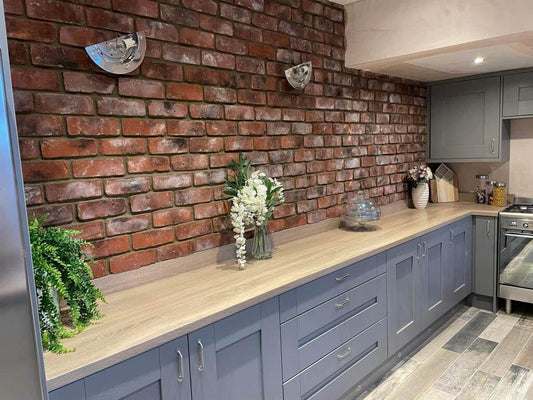 Rustic kitchen with Terrace Red Blend Brick Slips, grey cabinets, wooden countertop, and decorative plants.