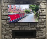 Stone cladding wall featuring a TV above a modern fireplace, showcasing a picturesque canal view.